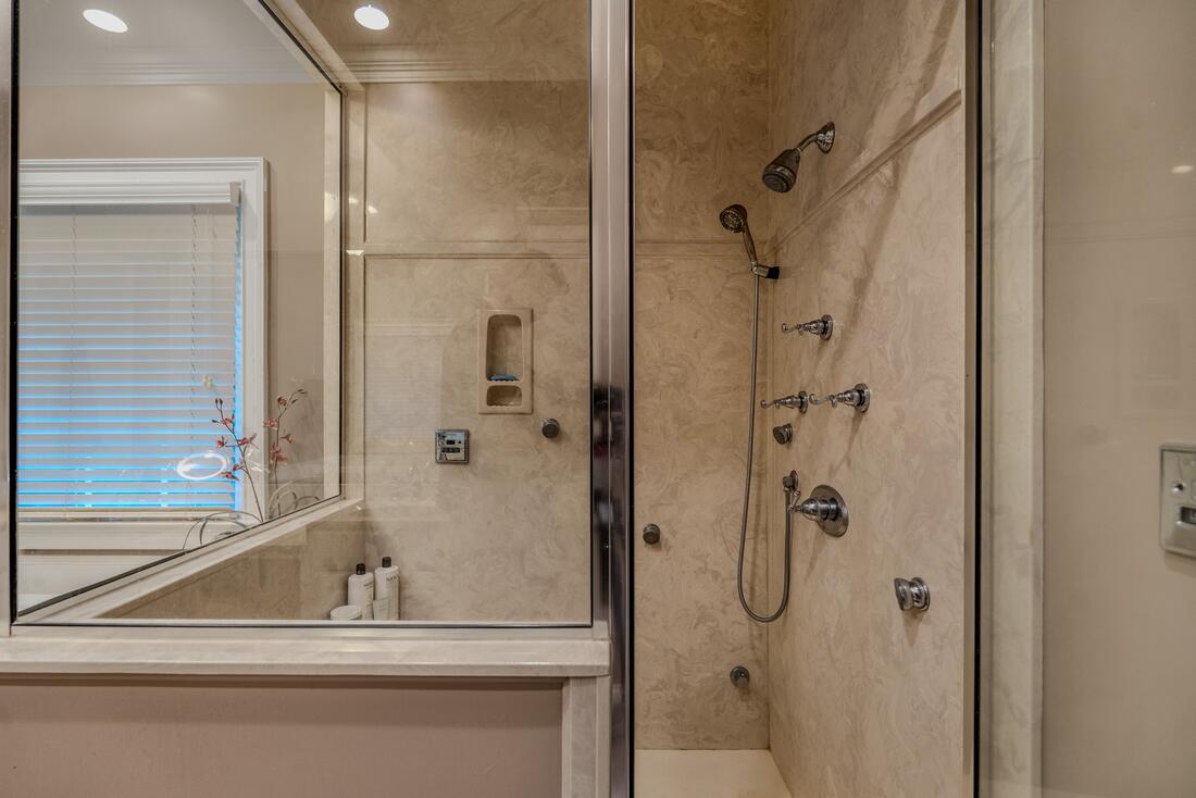 Glass-enclosed steam shower in the primary bath
